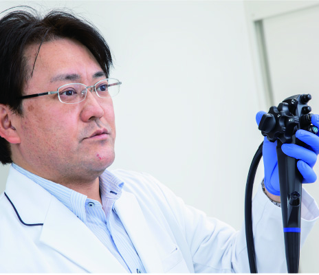 内視鏡カメラを持つ院長鈴木淳司